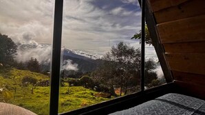 A room with a large window offering a view of a mountainous landscape.