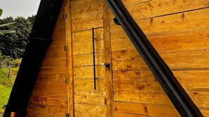 A wooden structure with a triangular roof and a door.