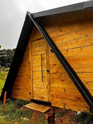 A wooden structure with a triangular roof and a door.