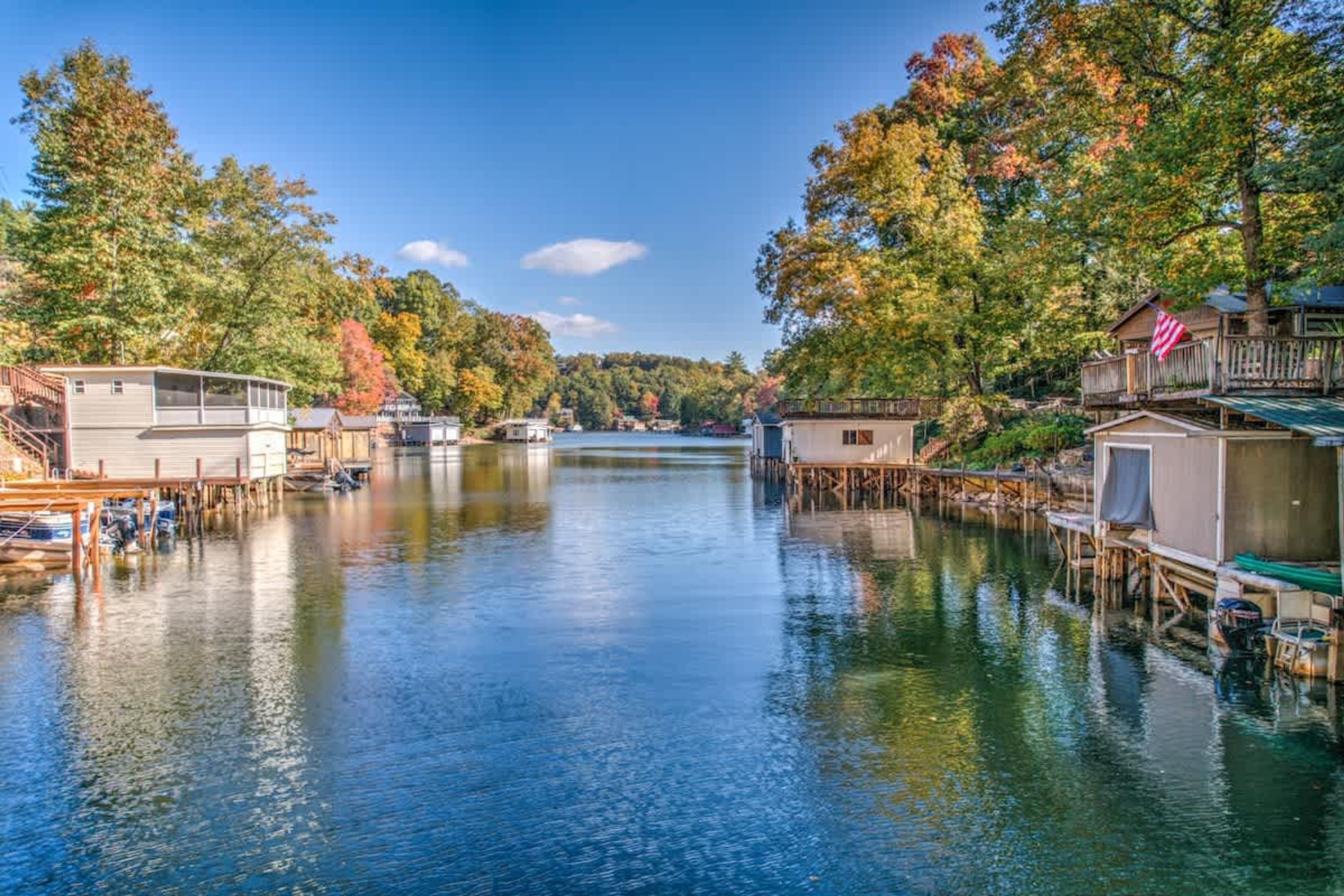 A waterfront property with docked boats, wooden structures, and a clear view of the water.