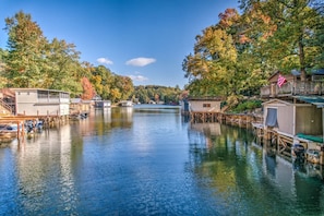 A waterfront property with docked boats, wooden structures, and a clear view of the water. - Dog Friendly Cottage on Lake Pontoon Available (Lake Lure)