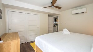 A bedroom with a bed, a desk, a ceiling fan, and an air conditioning unit. - Dog Friendly Cottage on Lake Pontoon Available (Lake Lure)