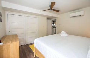 A bedroom with a bed, a desk, a ceiling fan, and an air conditioning unit. - Dog Friendly Cottage on Lake Pontoon Available (Lake Lure)