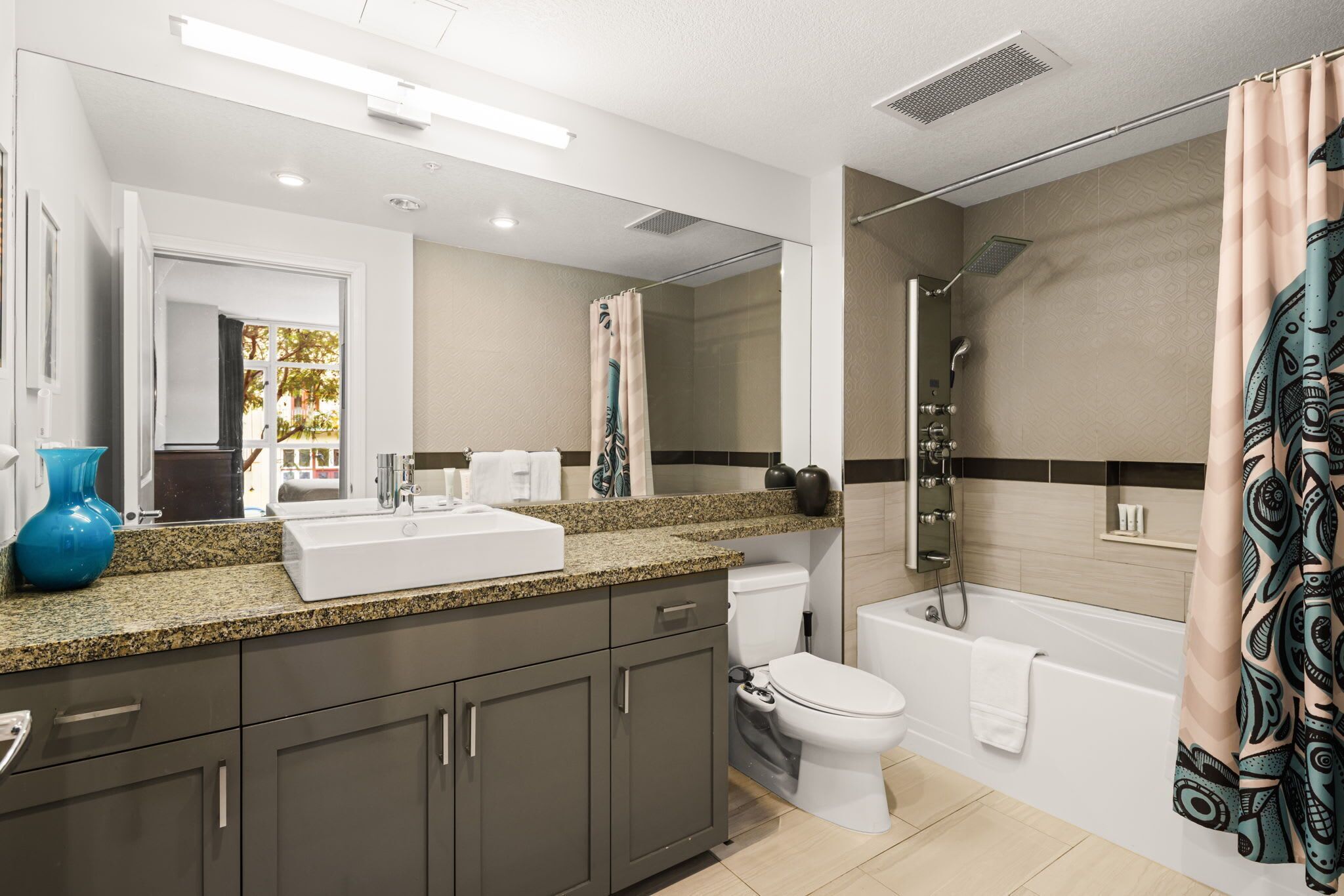 A modern bathroom with a sink, toilet, shower, and bathtub.