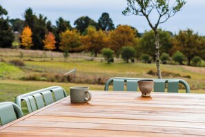 A wooden table with chairs, a mug, and a bowl.
