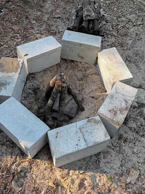 A circular arrangement of concrete blocks around a central fire pit.