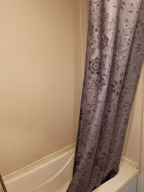 Una ducha con cortina de estampado floral.