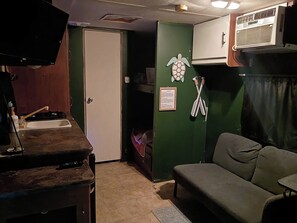 A compact room with a kitchenette, a sofa, and a small table. - RV stay private land 
The Angler's Hideout 
Close to springs, parks, & Daytona (Paisley)