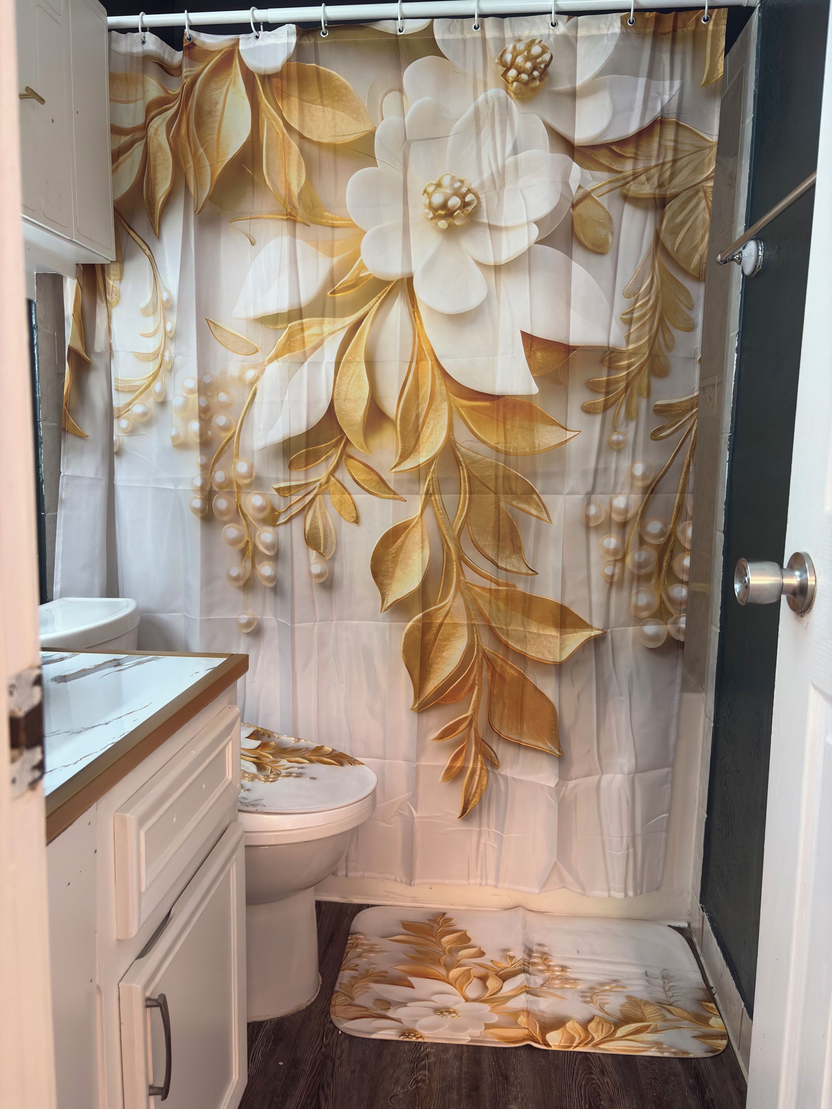 A bathroom with a toilet, a sink, and a shower curtain with a floral pattern.