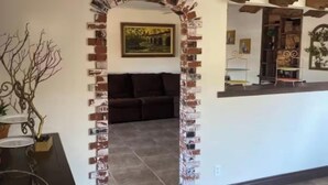 Un espace de vie comprenant un canapé, une plante décorative et un tableau encadré accroché au mur.