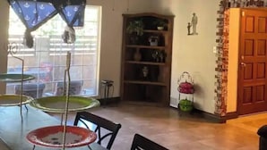 Un coin repas comprenant une table et des chaises, un ventilateur de plafond et une bibliothèque.