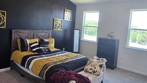 A bedroom with a bed, a dresser, a chair, and a window. - Relaxing Small Town Getaway in Bright 3B/3.5 Ba TH in Wendell (Wendell)