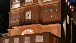 Un edificio de varios pisos con diseño arquitectónico tradicional, que presenta elaborados diseños en las ventanas y una entrada destacada.