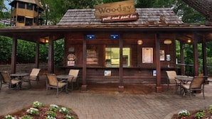 Un edificio rustico in legno con un cartello che recita 'Woody grill and pool bar'.