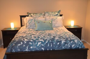 A bed with a leaf-patterned bedspread, two bedside tables with lamps, and a headboard. - Spacious Family-Friendly Phinney Flat Near Zoo (Seattle)