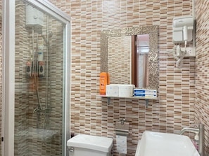 A bathroom with a glass shower enclosure, a toilet, and a sink. - MDM HOTEL  (Cordova)