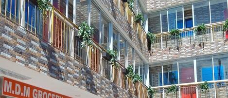 A multi-story hotel with a grocery store, laundry service, and reception on the ground floor.