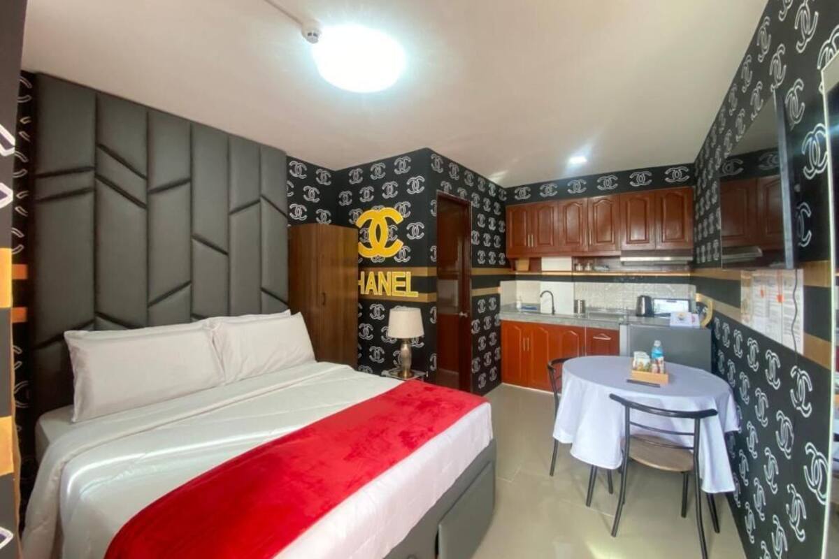 Una habitación de hotel con cama, escritorio y kitchenette.