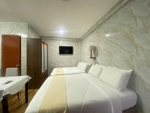 A hotel room with two beds, a TV, a desk, and a lamp. - MDM HOTEL  (Cordova)