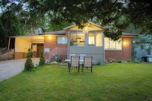A house with a small porch, a covered outdoor seating area, and a brick exterior. - Spacious 5 bedroom Niagara Falls retreat. Minutes to USA Canada cross border! (Niagara Falls)