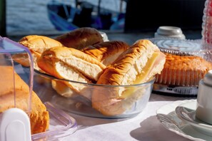 Una mesa con un bol de vidrio transparente que contiene sándwiches y un pastel.