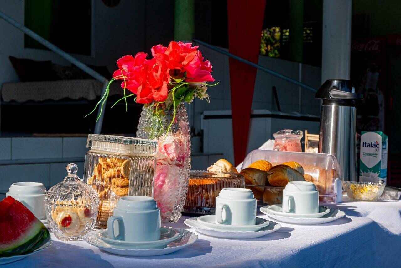 A table set with breakfast items including pastries, bread, and a thermos.