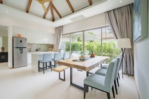 A modern kitchen with white cabinets, a built-in oven, and a stainless steel refrigerator. - Trichada Villa 4 Luxury Residences (Thalang)