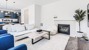 Una sala de estar moderna con sofá, mesa de centro y chimenea.
