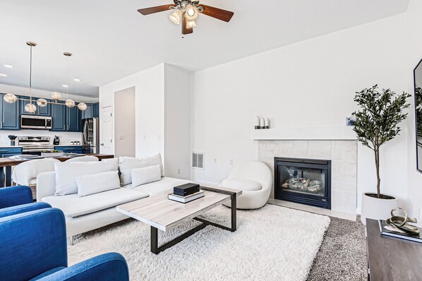 Ein modernes Wohnzimmer mit Sofa, Couchtisch und Kamin.