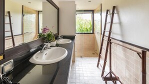 Une salle de bain avec deux lavabos, un miroir et une fenêtre.