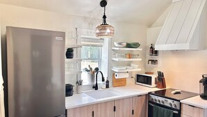A modern kitchen with a refrigerator, microwave, stove, and wooden cabinets. - Rural Retreat. Private yard, fire pit. 3-30 mins to attractions & conveniences (Bothwell)