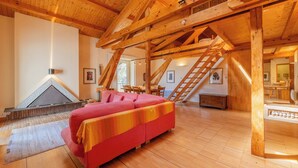 A spacious room with wooden beams, a red sofa, a fireplace, and a staircase. - Bel'Alp 24 Historical Residence Near Ski Lifts at Le Tour in Chamonix, Le Tour (Argentière), France (Le Tour (Argentière))