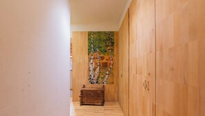 A hallway with wooden flooring, a wooden cabinet, and a decorative wall painting. - Bel'Alp 24 Historical Residence Near Ski Lifts at Le Tour in Chamonix, Le Tour (Argentière), France (Le Tour (Argentière))
