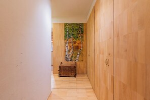 A hallway with wooden flooring, a wooden cabinet, and a decorative wall painting. - Bel'Alp 24 Historical Residence Near Ski Lifts at Le Tour in Chamonix, Le Tour (Argentière), France (Le Tour (Argentière))