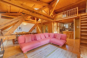 A wooden interior with a pink sectional sofa, wooden beams, and a staircase. - Bel'Alp 24 Historical Residence Near Ski Lifts at Le Tour in Chamonix, Le Tour (Argentière), France (Le Tour (Argentière))