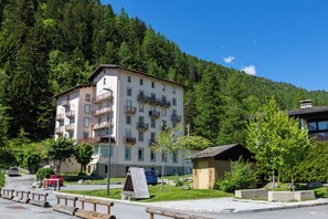 A multi-story building with balconies, a parking area, and a forested hillside in the background. - Bel'Alp 24 Historical Residence Near Ski Lifts at Le Tour in Chamonix, Le Tour (Argentière), France (Le Tour (Argentière))