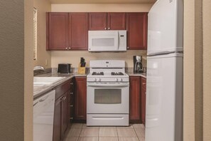 Eine kompakte Küche mit Mikrowelle, Herd, Backofen und Kühlschrank.