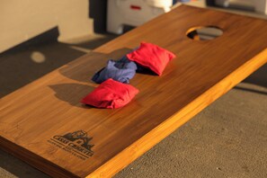 Een houten plank met een logo en tekst, en twee rode kussens erop.