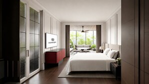 Une chambre moderne avec un grand lit, une télévision, un bureau et une vue sur la verdure.