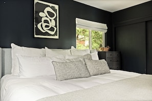 A bedroom with a bed, pillows, a window, and a wall art piece. - PREMIER 4BR LAKEFRONT HOME + BEST VIEWS + GENERATOR + EASY ACCESS TO LAKE (Crestline)