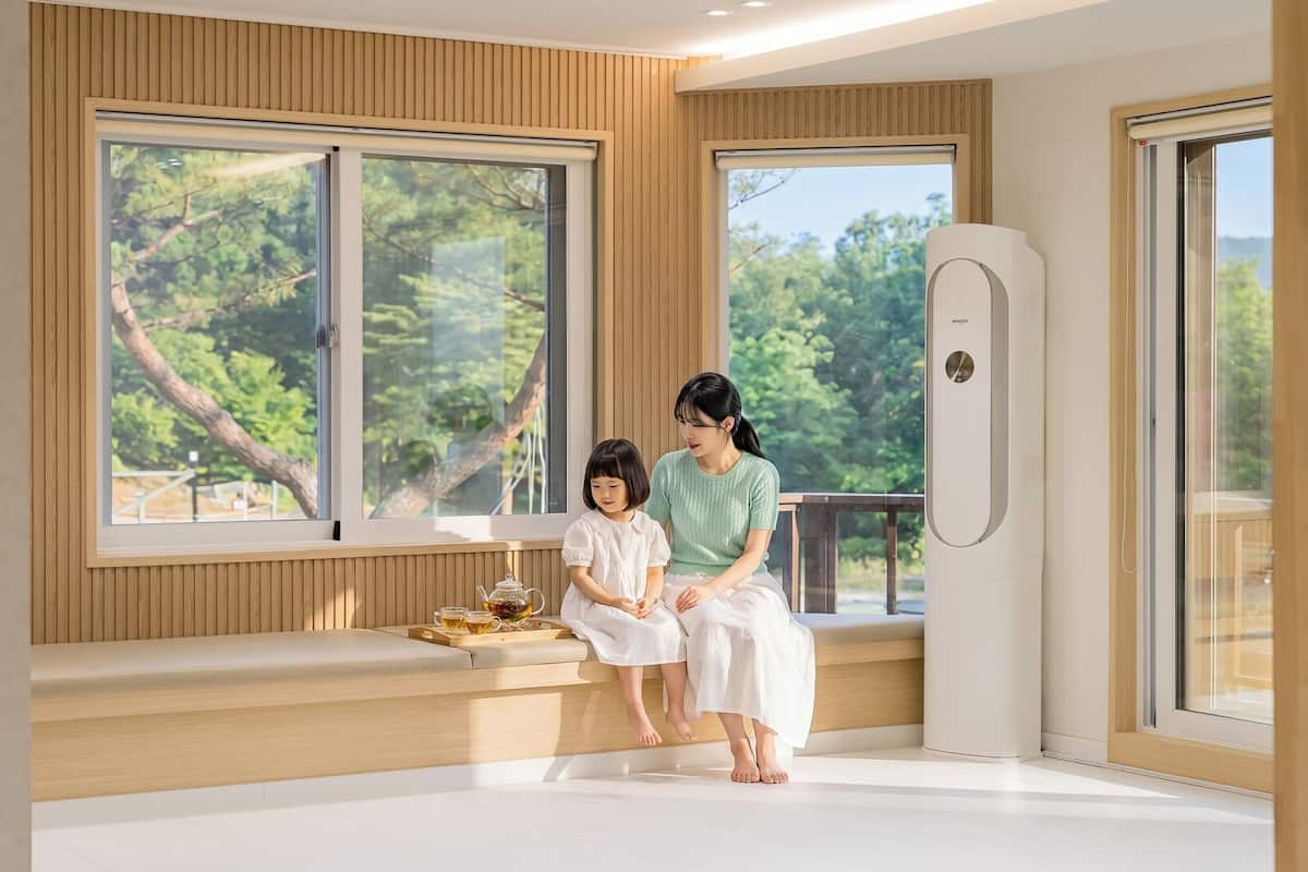 Una habitación con ventanas amplias, un banco y un purificador de aire moderno.