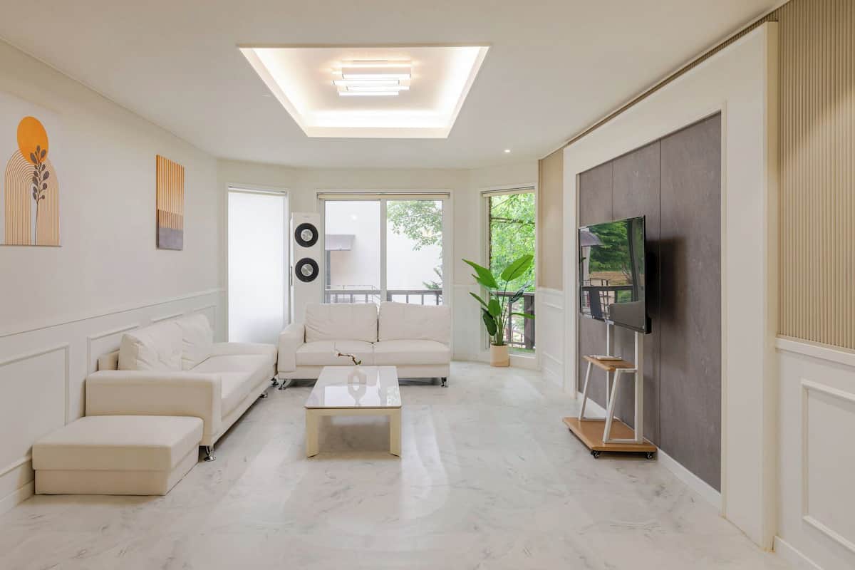 Una sala de estar moderna con un sofá, una mesa de centro y un televisor.