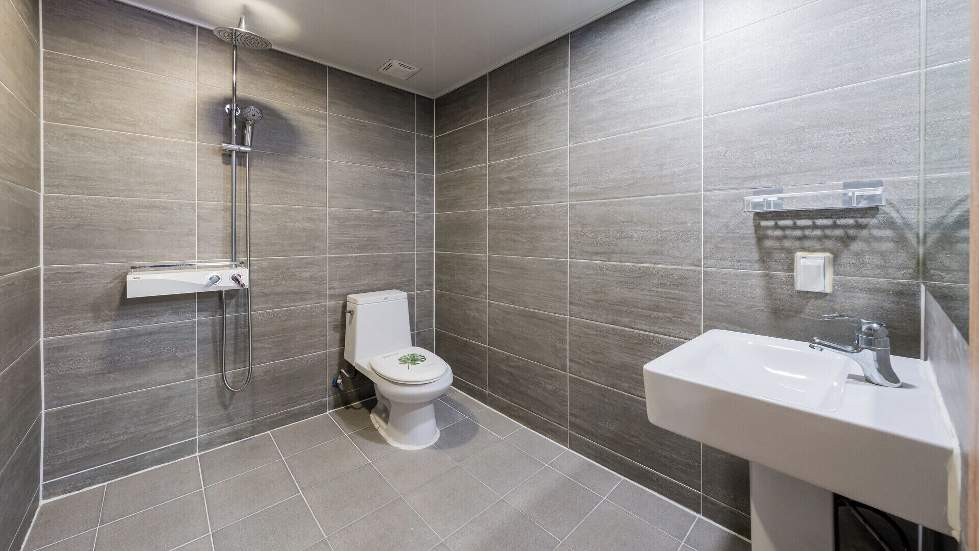 Un baño moderno con ducha, inodoro y lavamanos.