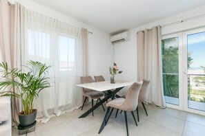 A dining area with a table, chairs, a potted plant, and a view of the outdoors. - Two bedroom apartment with a swimming pool Marina, Trogir (A-27449-b) (Marina)