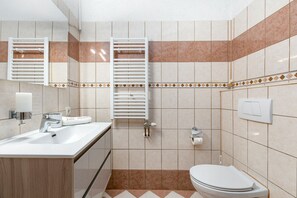 A bathroom with a sink, mirror, towel rack, toilet, and tiled walls. - Two bedroom apartment with a swimming pool Marina, Trogir (A-27449-b) (Marina)