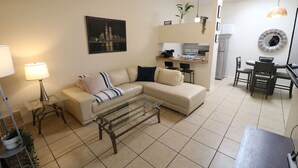 Ein Wohnzimmer mit einer Couch, einem Couchtisch und einem Essbereich mit Stühlen und einem Tisch.