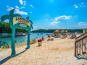 A beach with a sign reading 'Landshark Landing Marina'.