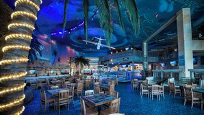 A spacious indoor area with multiple dining tables and chairs, a large pillar with lights, and a ceiling with a mural. - Spacious Lake Lanier property - Close to Atlanta and full of amenities (Buford)
