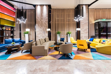 Una hall moderna con un divano componibile, poltrone, un tavolino e una libreria.. Hampton by Hillton Xiamen City Plaze