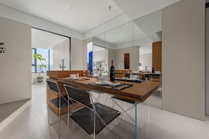 Une cuisine moderne avec un coin repas, comprenant une table en bois, des chaises et des appareils de cuisine.